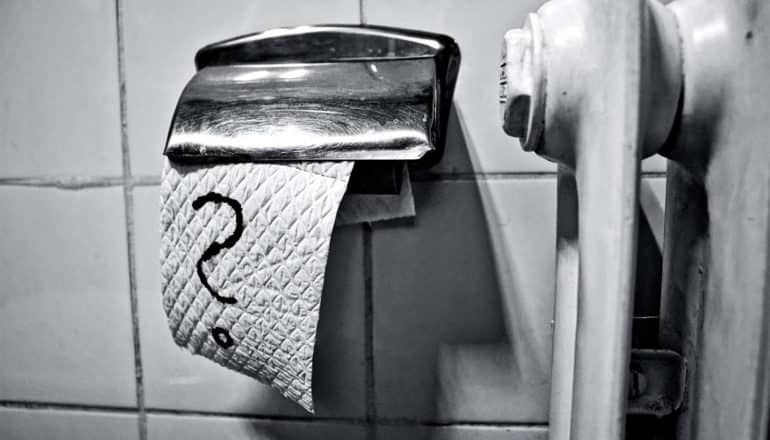 A piece toilet paper in a bathroom has a question mark drawn on it