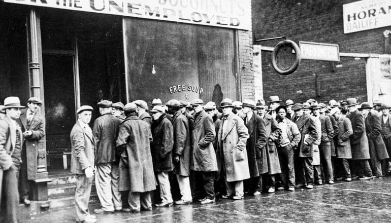 A line of unemployed people wait for free soup