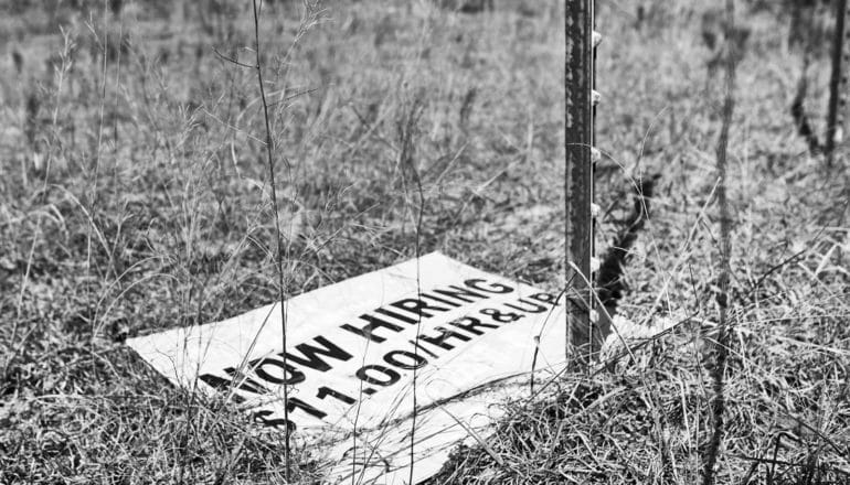 fallen sign says "now hiring $11/hour and up"