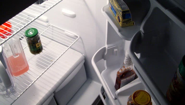 fridge with just a little juice and a few condiments inside