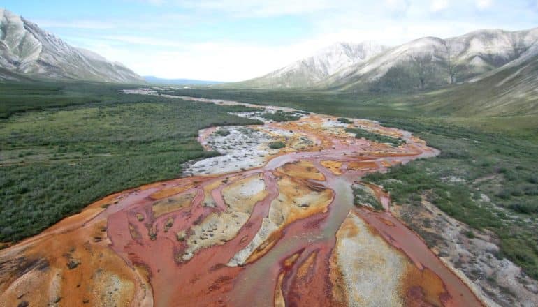 reddish water flows between mountains