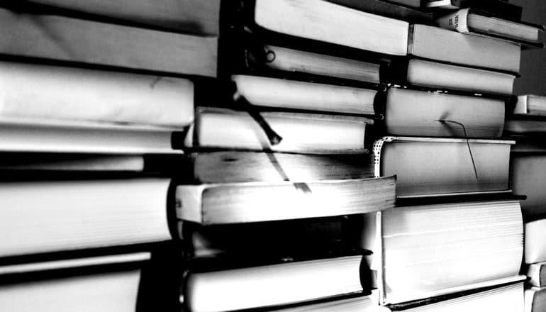 Stacks of thick books in black and white