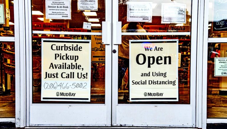 signs on store door say "curbside pickup available just call [number]" and "yes we're open and using social distancing mudbay"