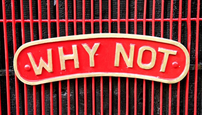 red sign with plaque reading "WHY NOT"