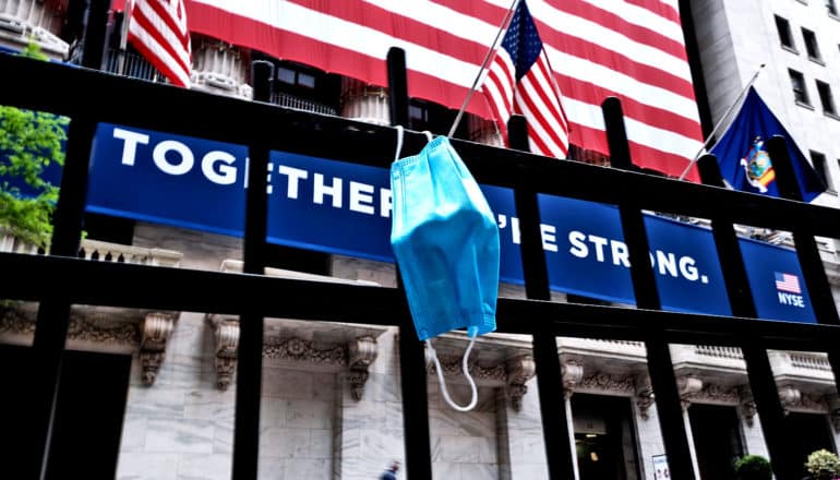 A medical mask hangs on a fence across the street from the New York Stock Exchange