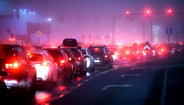 Cars sit bumper-to-bumper at night