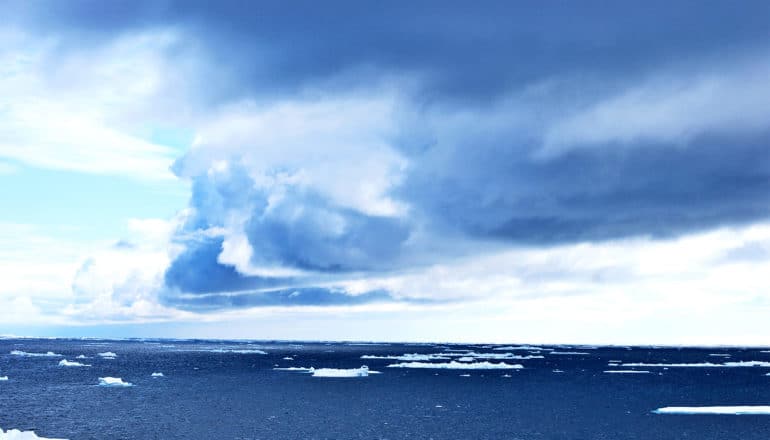 Dark clouds hover over a dark blue ocean