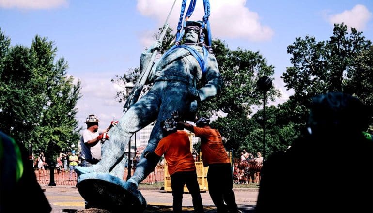 Workers bring down a confederate monument of a soldier