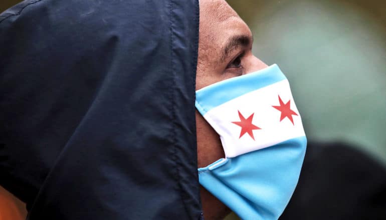 A man wears a mask with blue stripes and red stars in a white bar to prevent coronavirus transmission