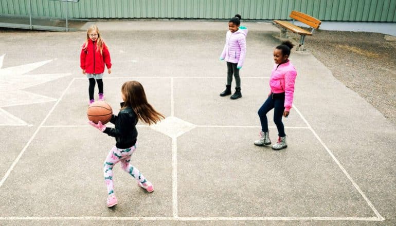 kids play foursquare on cement