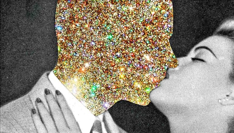 A black and white photo of a man kissing. The man's face is covered in gold glitter