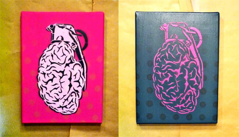 Two paintings of brains as grenades hang on a wall