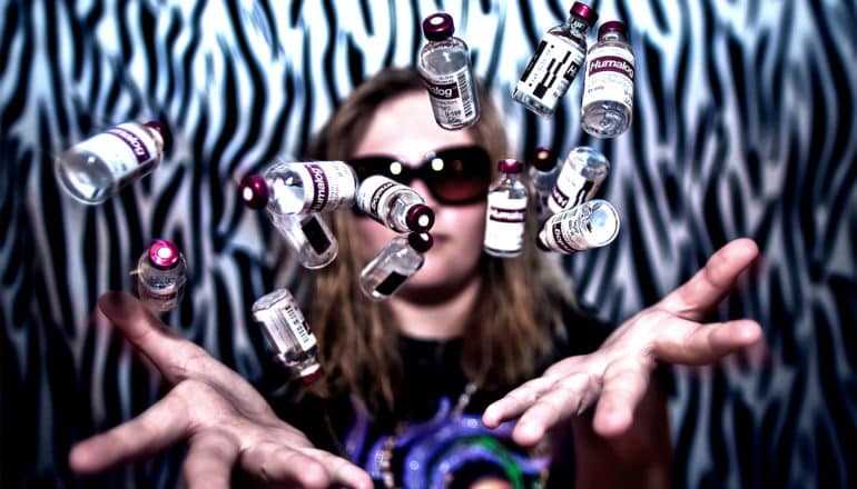 A young woman throws a bunch of insulin bottles in the air