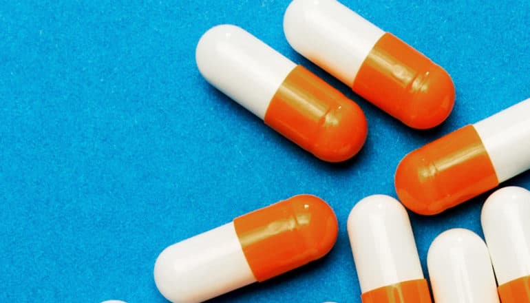 Orange and white pills on a blue background