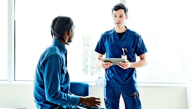 A young man speaks to a nurse in a doctor's office