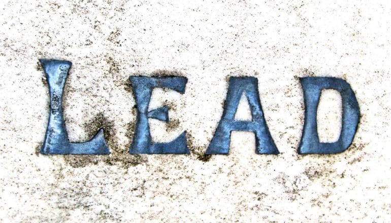 The word "lead" spelled out in lead letters in concrete