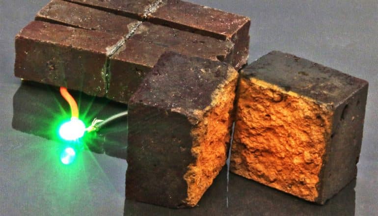 A wire coming from a brick connects to a bright green light