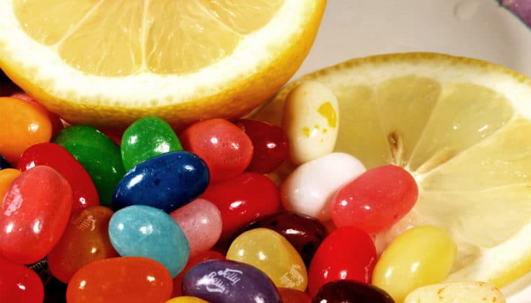 Jellybeans sit next to slices of lemon