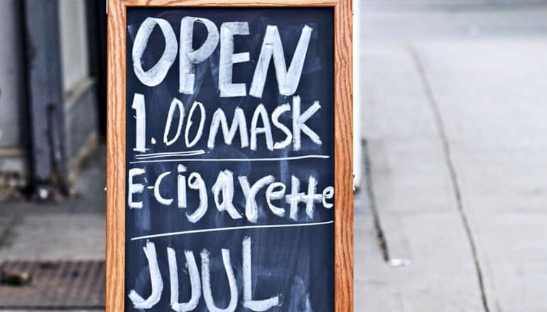 A sign advertises face masks and e-cigarettes