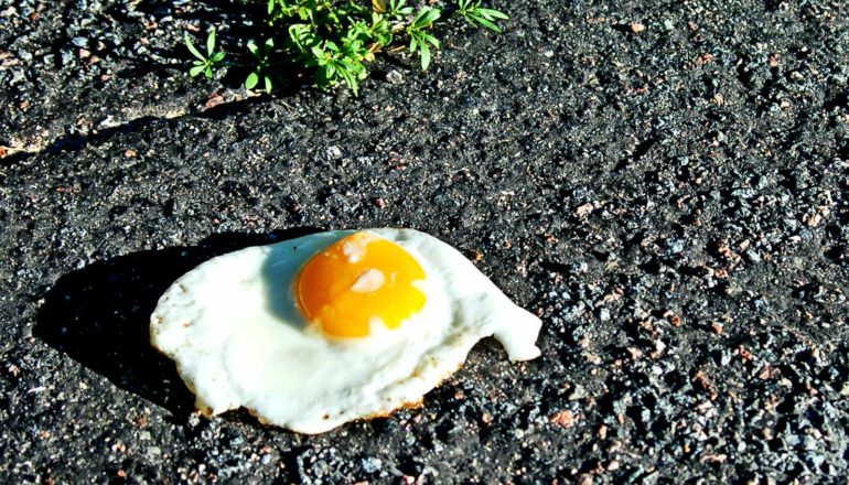 An egg fries on hot asphalt