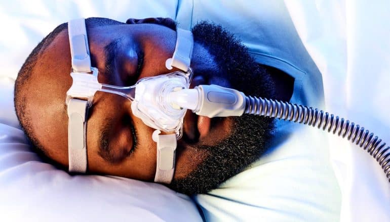 A man sleeps with a CPAP machine for sleep apnea