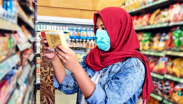 A young woman looks at a food package