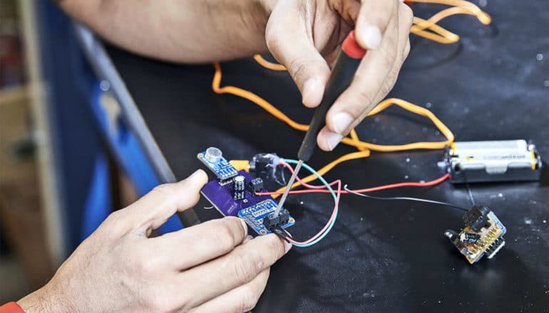 A researcher works on the electronics for the hearing aids