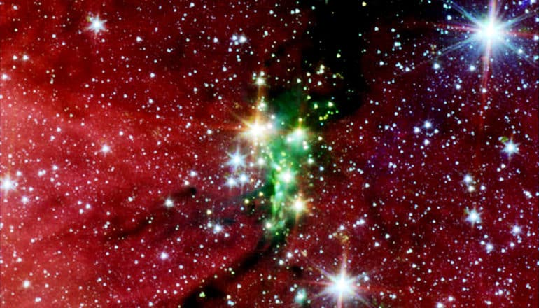 A cluster of stars within a reddish haze in space