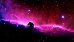 A purple molecular cloud against the starry blackness of space