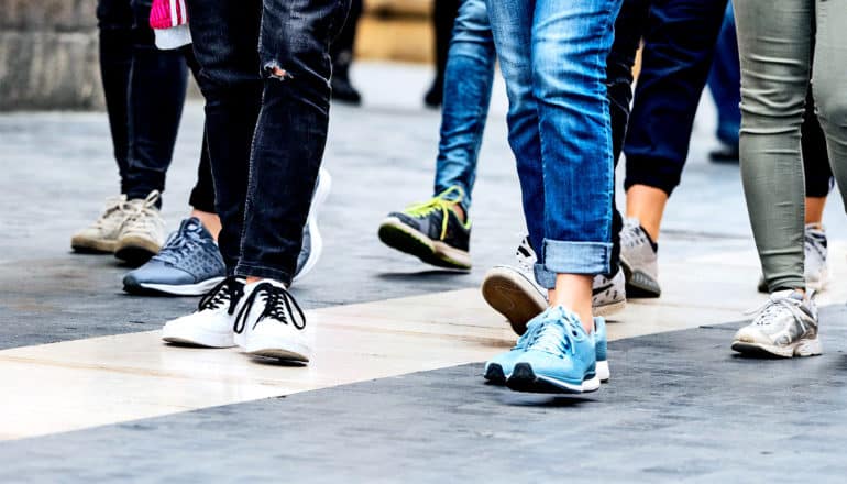 A group of young people walk down a street together