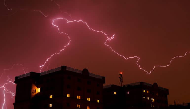 lightning in pink sky over large building