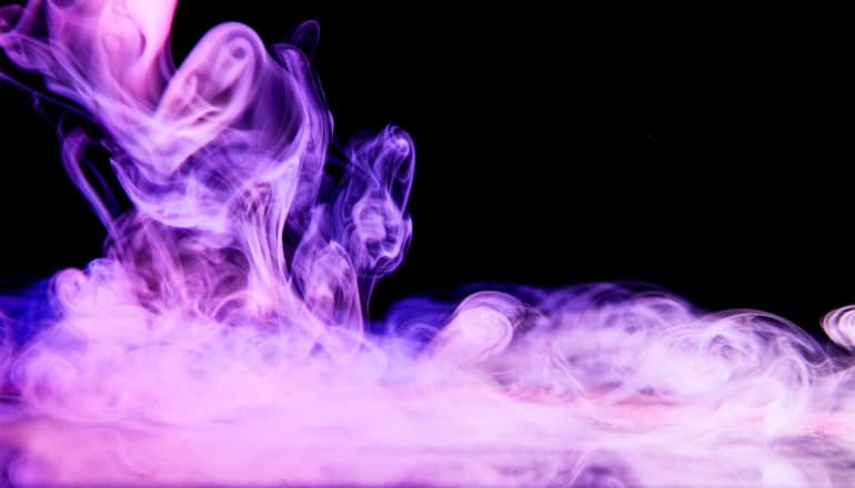 Purple mist floats against a black background