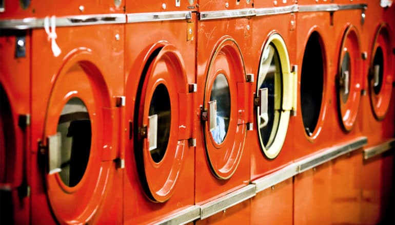 A row of orange washing machines