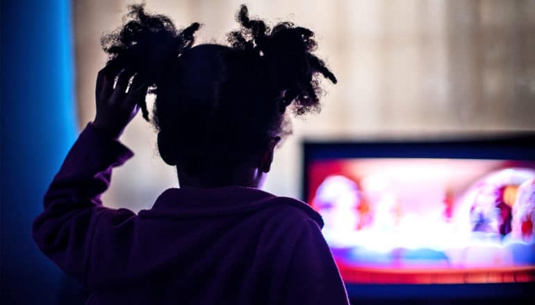 A young girl watches TV