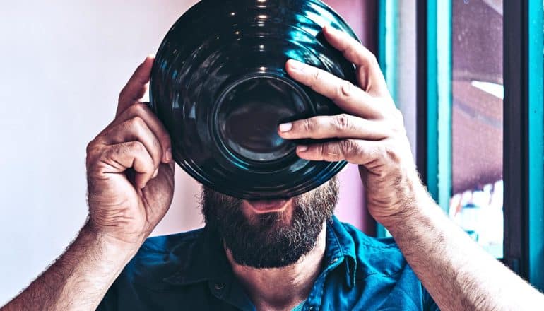 A man sips from a bowl as he holds it up to his face