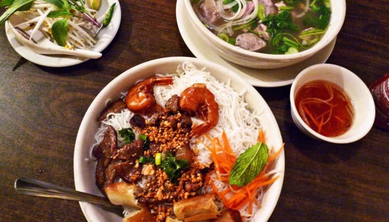 bowls of pho and condiments