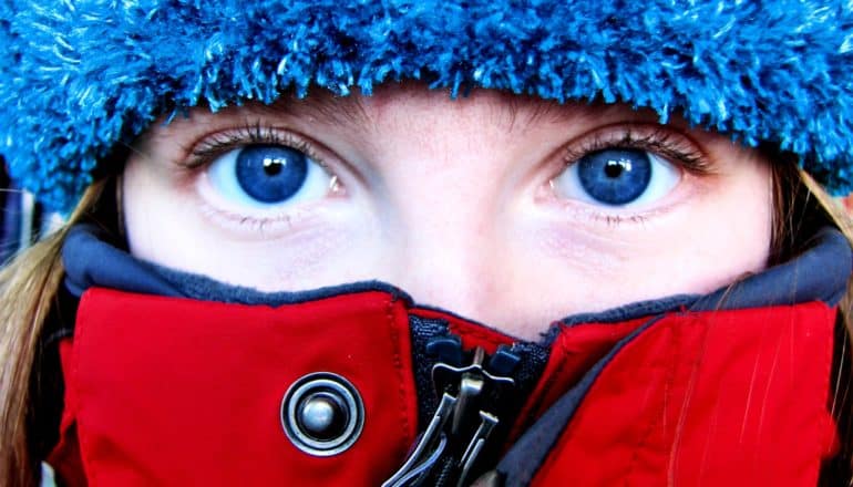 A young woman in winter gear with only her eyes showing