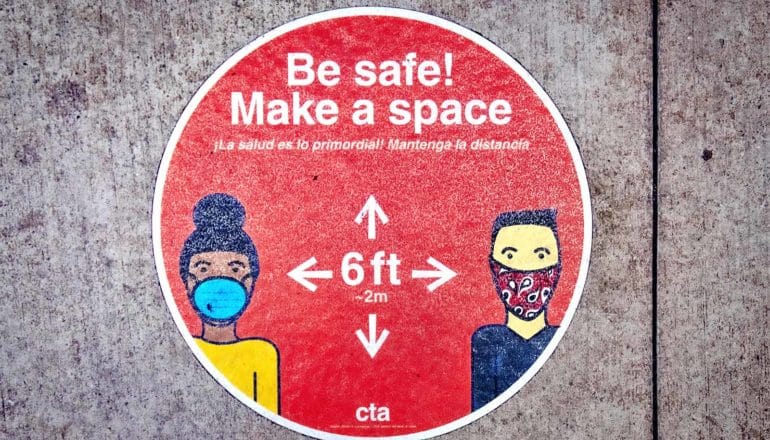 A sign reads "Be Safe! Make a space!" and shows two people in face masks with 6 feet measured between them