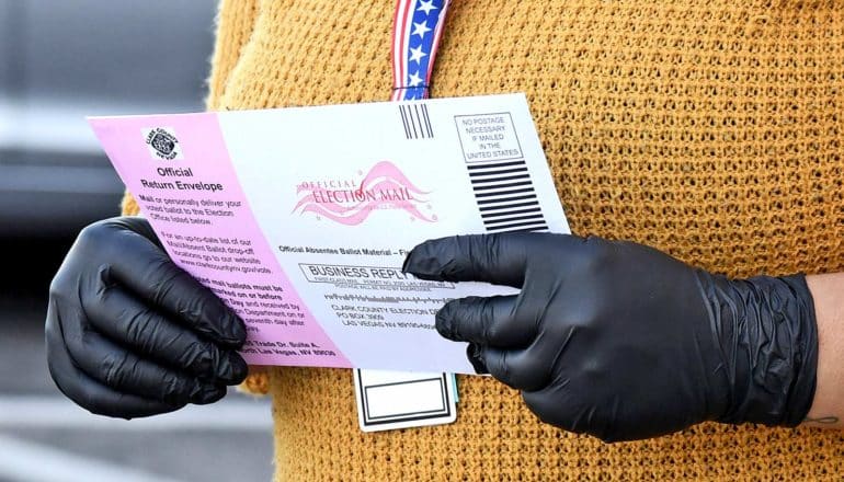 gloved hands hold ballot