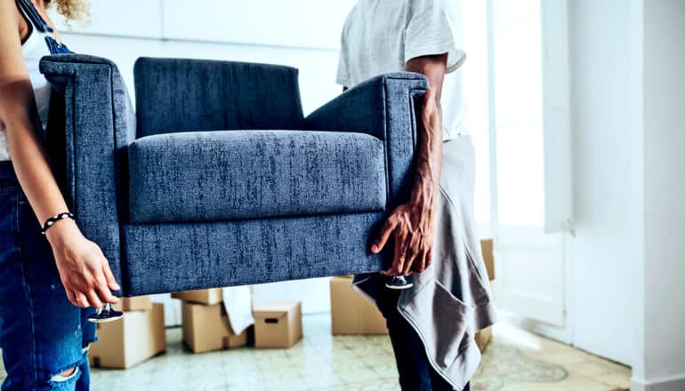 A couple moving an armchair