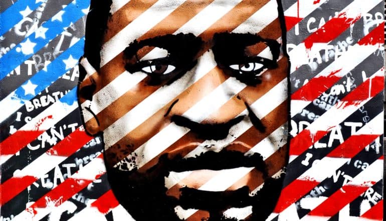 A painting of George Floyd's face, with the American flag striped across his face, and the words "I Can't Breathe" painted beneath repeatedly