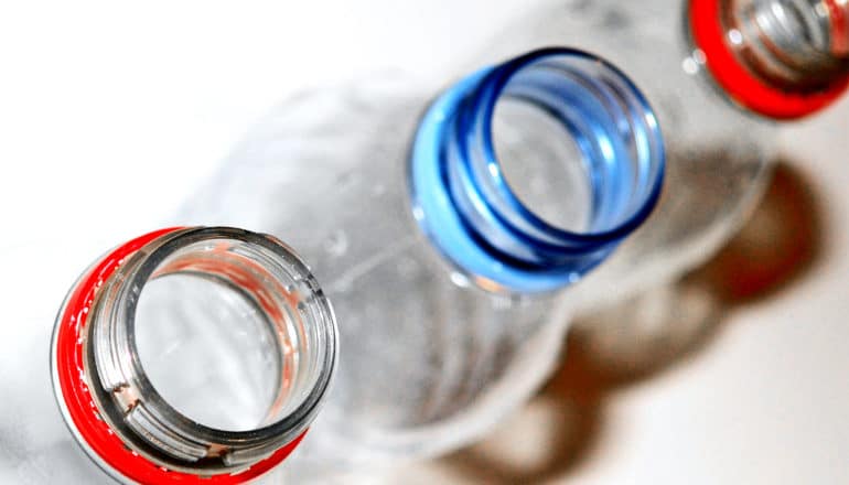 Three plastic bottles in a row on a white background