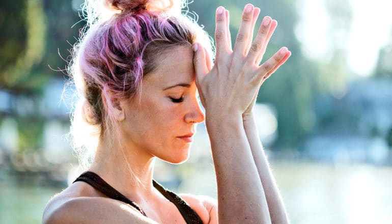 A woman holds her hands to her head looking stressed