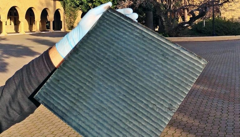 A researcher holds up a perovskite solar cell