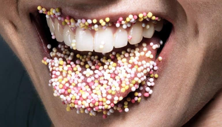 round sprinkles on lips and tongue