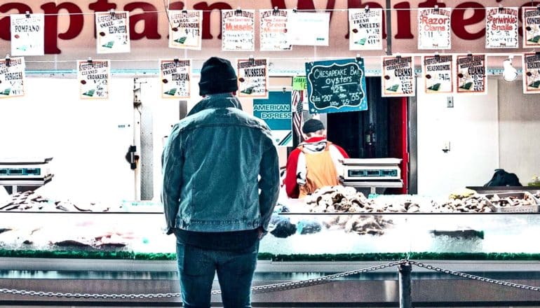 A man waits at a seafood counter