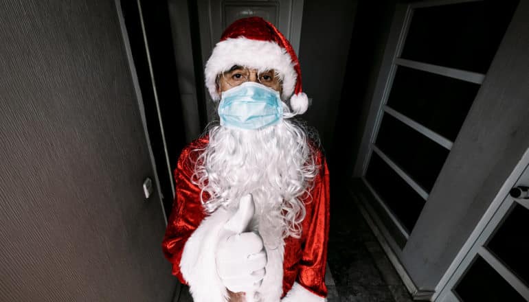 grim santa in mask gives thumbs up