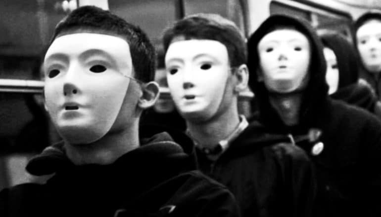 A group of people wear white masks that cover their faces