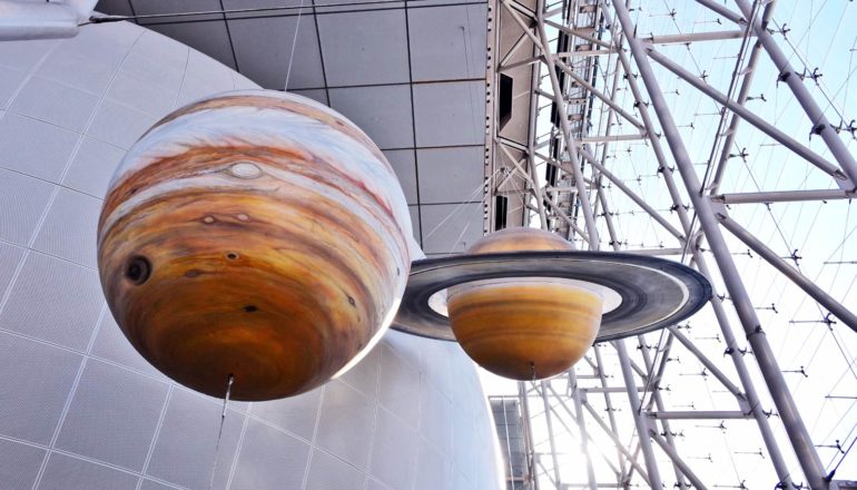 models of jupiter and saturn hang in museum