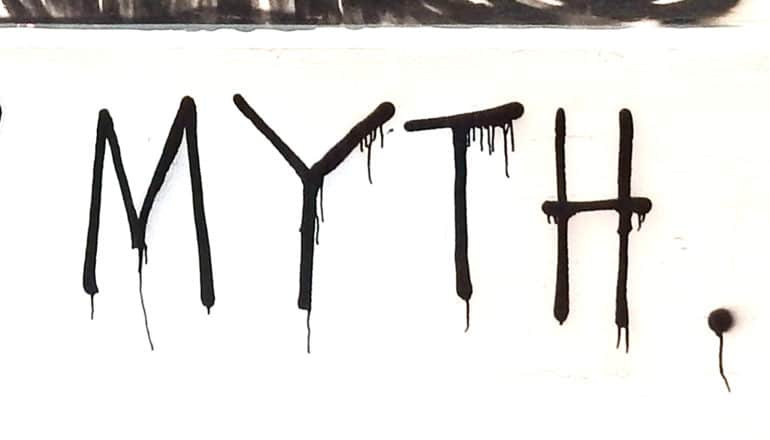 The word "myth" is spray-painted in black on a wall